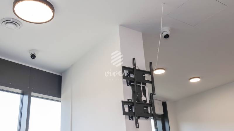 Ceiling with cameras, TV mount, and lighting in commercial premises.
