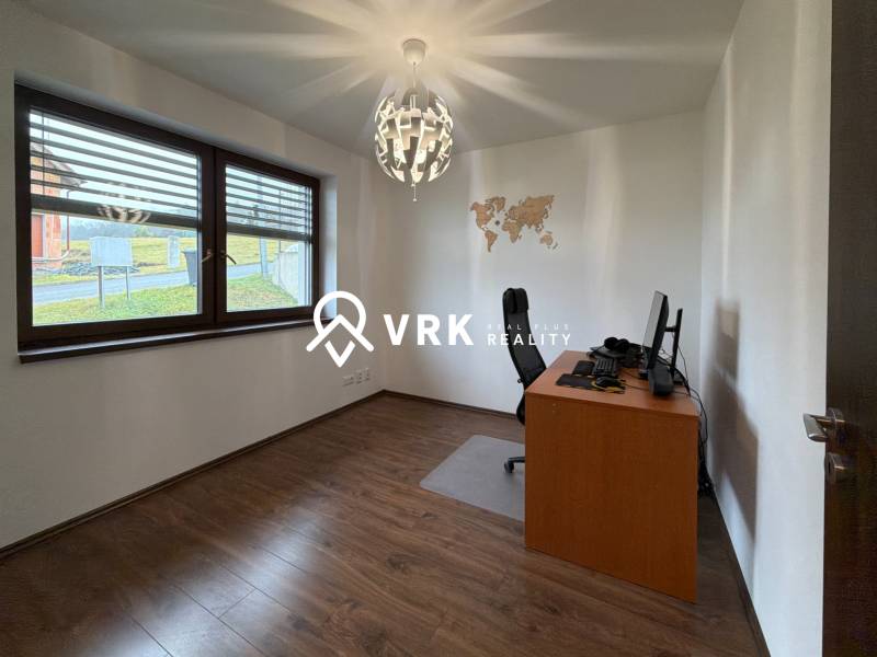 Office in a family house with a map on the wall, floor with wooden decor.