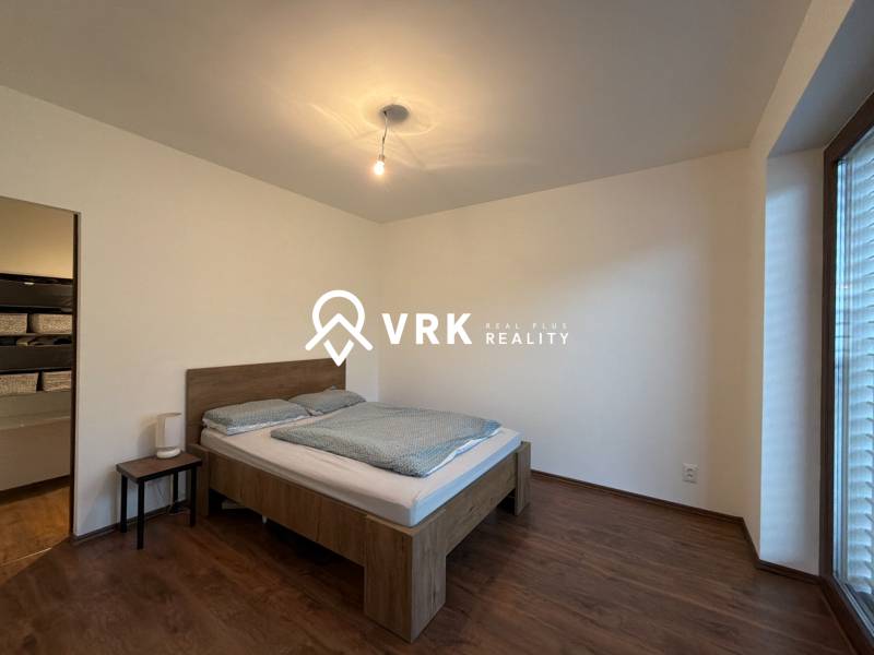 Bedroom with wood-patterned flooring and a comfortable bed in a family house.