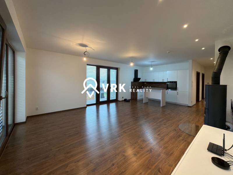 Living room with kitchen in a family house, wooden decor flooring, bright and spacious environment.