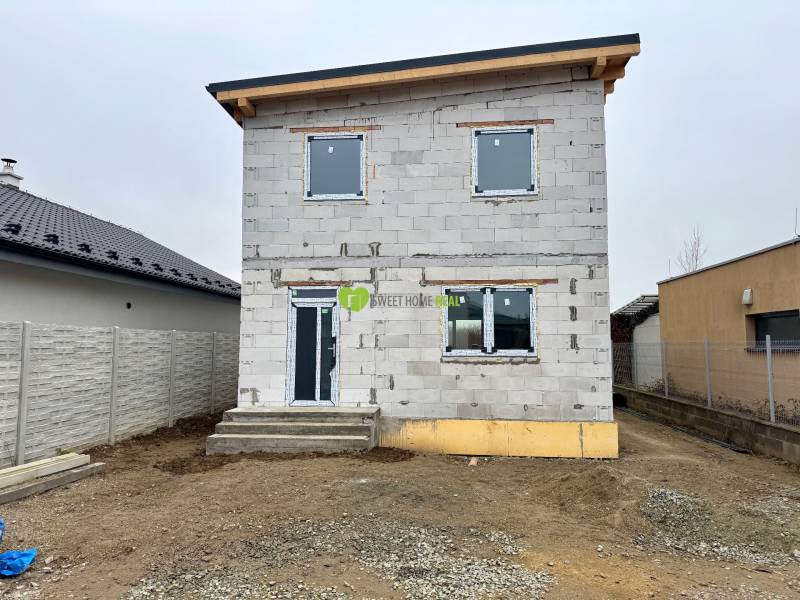 A family house on Hviezdna Street in Čaňa with an unfinished facade and fencing.