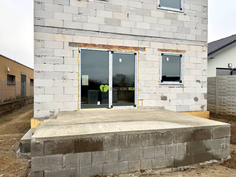 Construction of a family house on Hviezdna Street in Čaňa with an unfinished facade and a terrace.