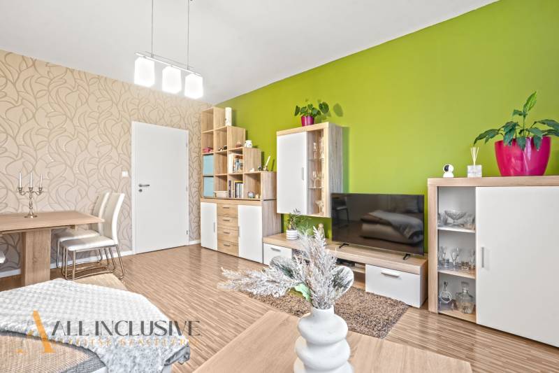 Interior of a 3-room apartment with light-colored walls, a colorful wall, and a floor with a wood decor.