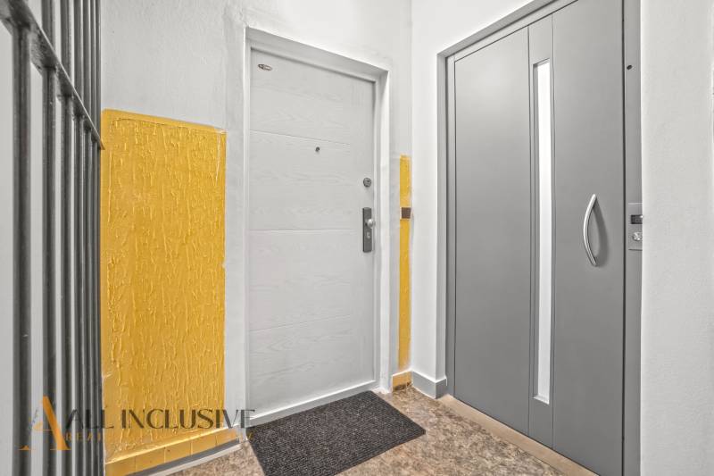Entrance door in a 3-room apartment, next to a gray elevator, yellow walls.