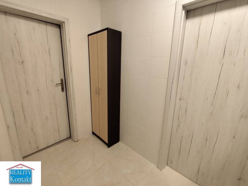 In a 2-room apartment, white doors with a subtle pattern and a narrow cabinet.