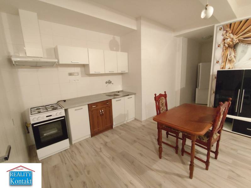 Kitchen in a 2-room apartment with a dining table, floor with wooden decor.