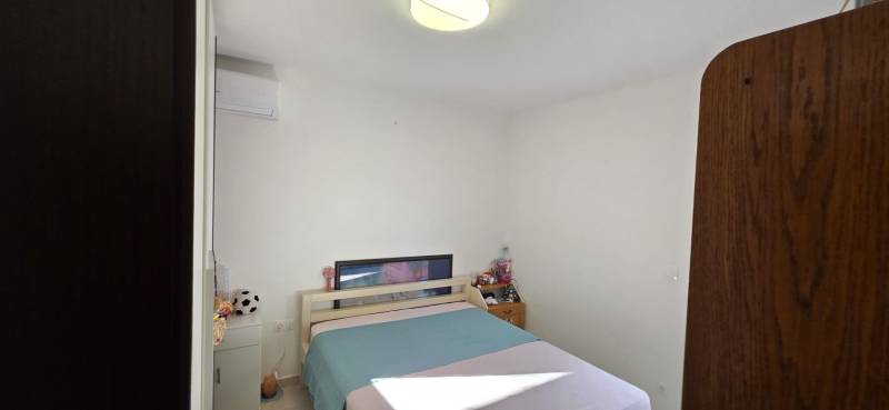 Bedroom with a double bed and a cabinet in a 3-room apartment.