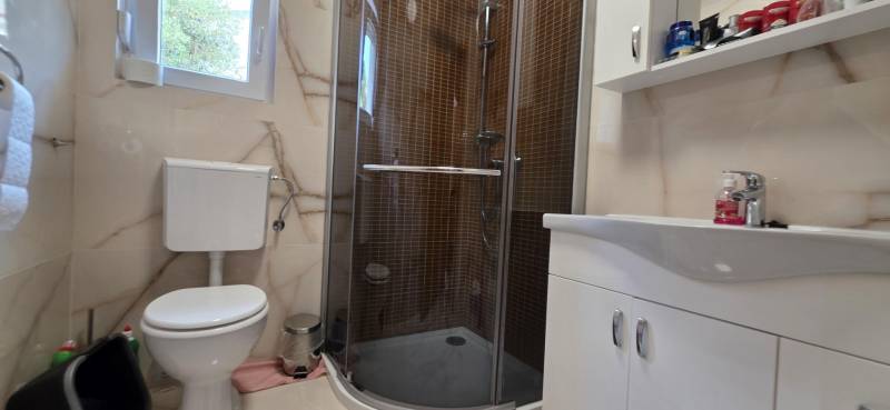 Bathroom in a 3-room apartment with a toilet, shower, and sink.