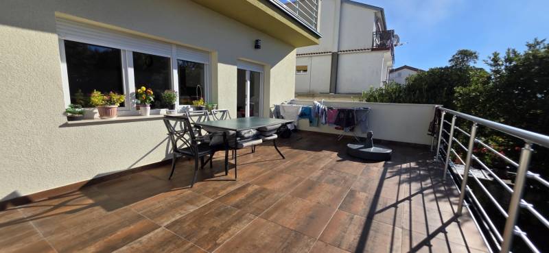 Terrace of a 3-room apartment in Crikvenica, with furniture and a clothes dryer.
