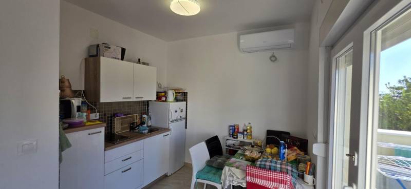 Kitchen in a 3-room apartment with a kitchenette, table, and appliances.