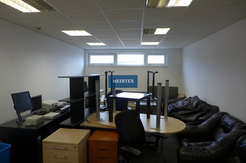 Office space with arranged furniture, white walls, a window, and a wooden decor floor.