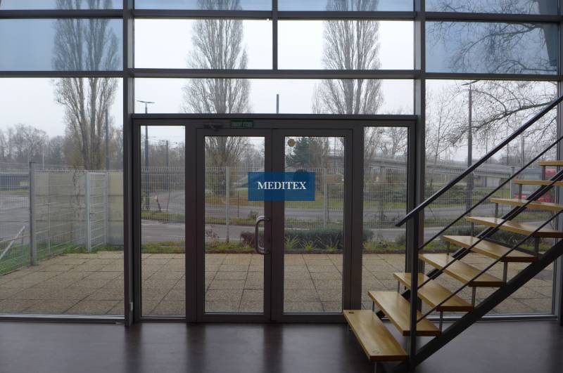 Interior of commercial premises with glass doors and a staircase with a wooden decor.
