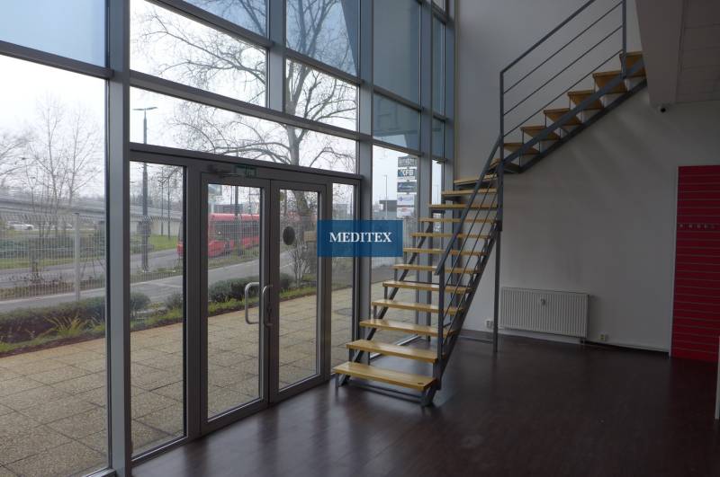Interior of commercial spaces with wood-patterned flooring and a staircase.