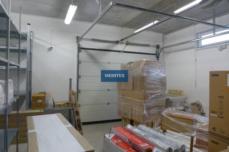 Storage spaces with boxes, steel shelves, and a roll-up door.