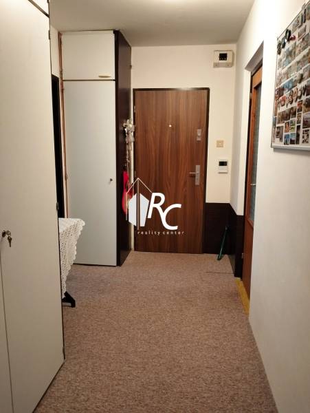A hallway in a 3-room apartment with wardrobes and doors with a wooden decor.