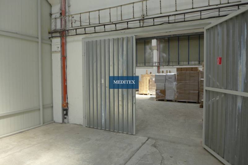 Warehouses and halls with steel gates and pallets of goods.