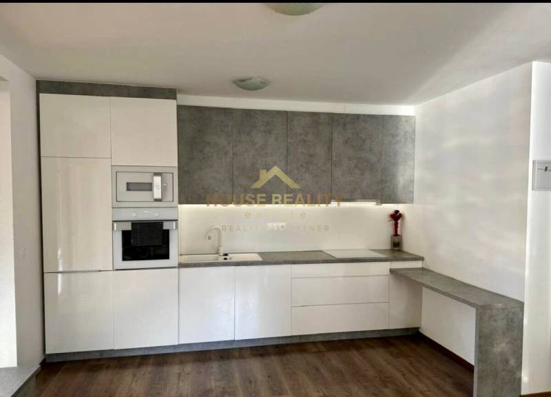 A kitchen in a 3-room apartment with white cabinets and a wood-patterned floor.