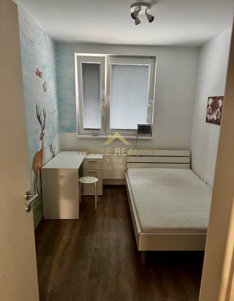 Children's room with one bed, a desk, and a floor with a wooden decor.