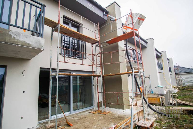 A family house in Nové Zámky during renovation, with scaffolding and balconies with railings.