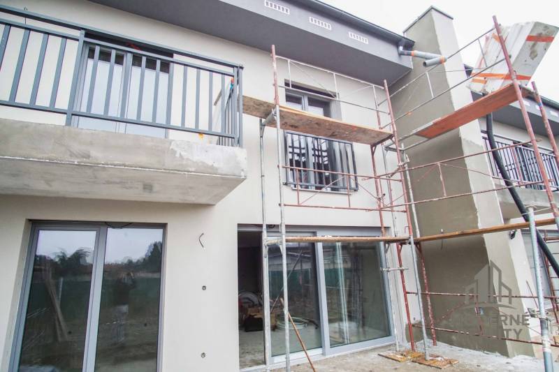 A family house in Nové Zámky during renovation, with construction scaffolding and glass doors.
