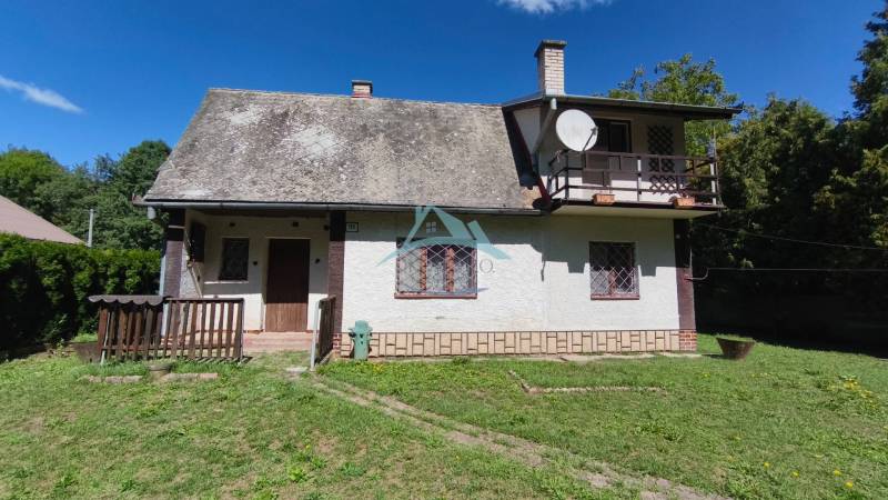A cottage in Dolné Strháre with a grassy plot surrounded by greenery and trees.