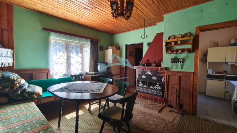 A wooden ceiling, fireplace, and traditional furniture in the cottage adorn the living room.