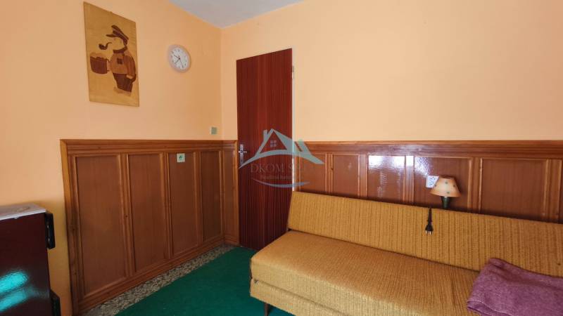 Part of the interior with wooden paneling, a sofa, and wall decoration in the cabin.