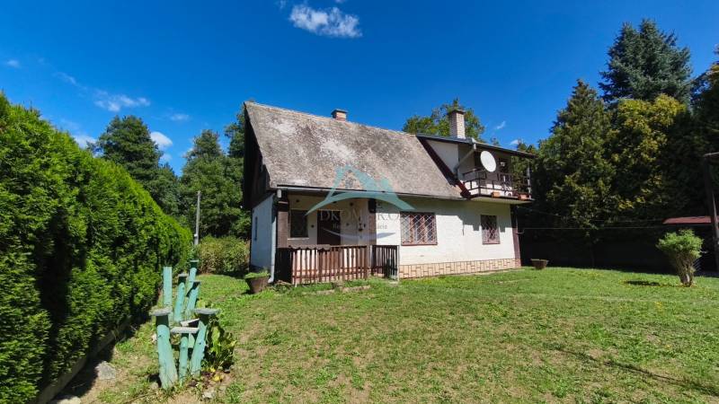 A cottage in Dolné Strháre surrounded by greenery and a clear sky.