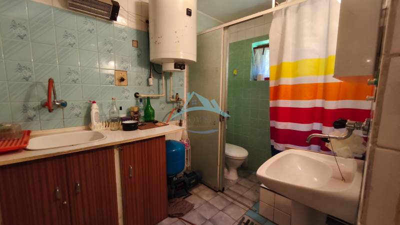 Bathroom in a cabin with blue tiles and a shower corner.