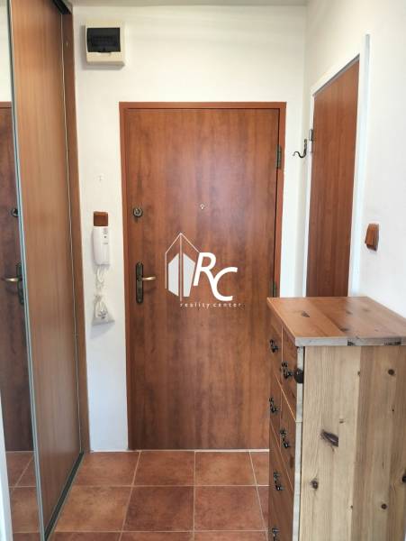 Entrance area in a one-bedroom apartment with a chest of drawers and a mirrored wardrobe.