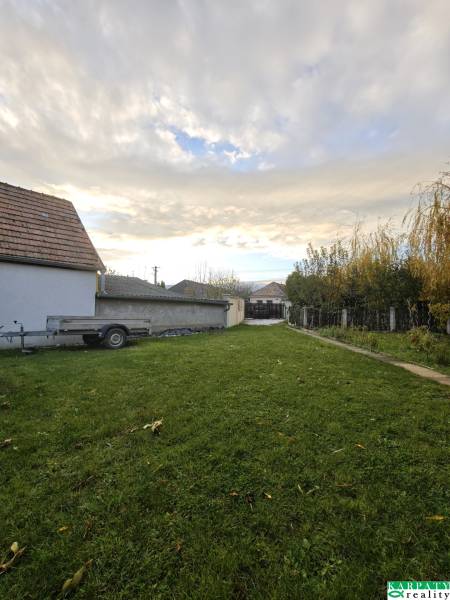 A family house on Krátka Street in Blatné with a grassy yard and a trailer.