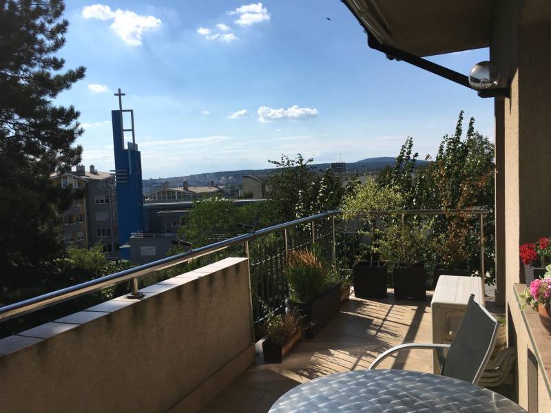 A balcony of a family house on Mozartova Street with a view of the church tower in Bratislava.