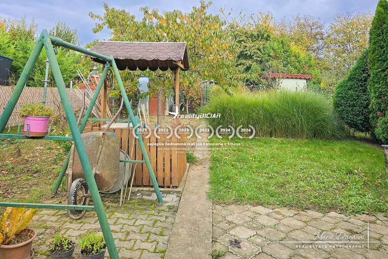 The garden of a 3-room apartment on Vajanského Street in Šaľa with a swing and a well.