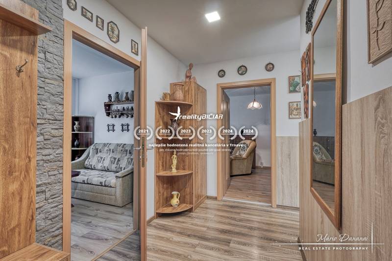 Interior of a 3-room apartment with wood-decor flooring, wall decorations, mirror.