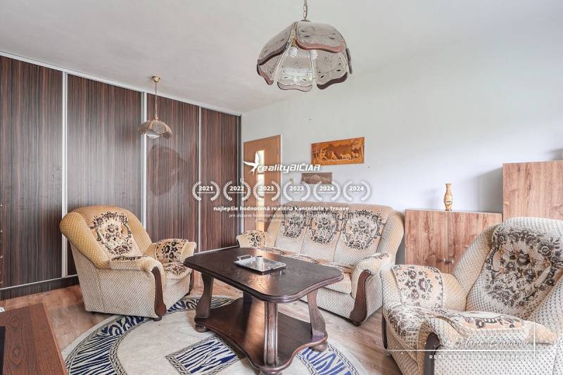 Living room in a 3-room apartment with comfortable seating and a wooden decor floor.