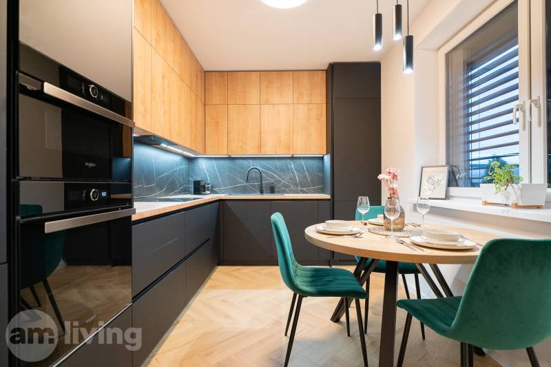 A kitchen in a 3-room apartment with a wooden decor floor and a dining table.