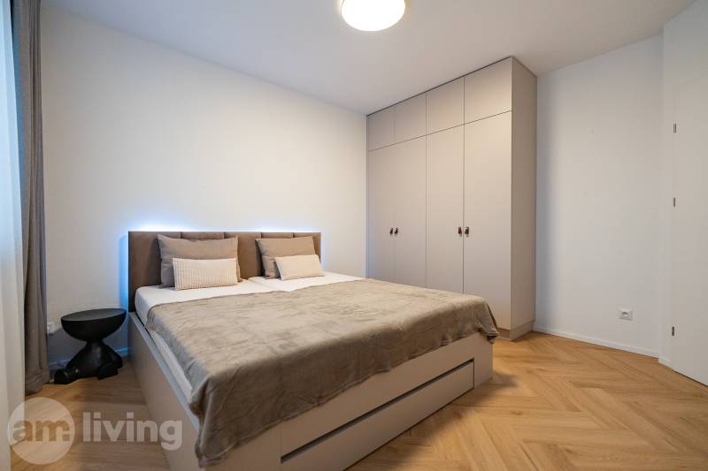 Bedroom in a 3-room apartment with a bed, built-in wardrobe, and floor with wood decor.