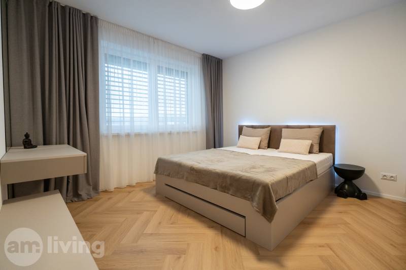 Bedroom in a 3-room apartment with a bed and wooden decor flooring.