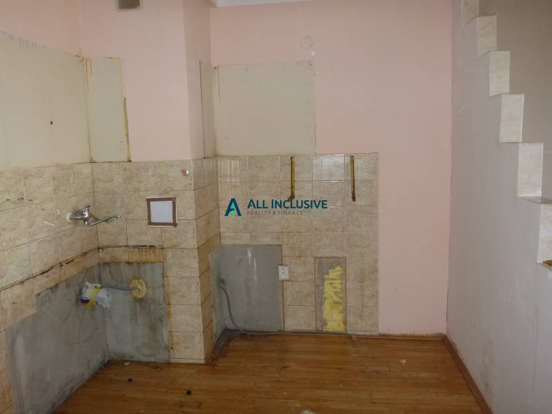 A two-room apartment with wooden decor flooring, ready for renovation and kitchen installation.