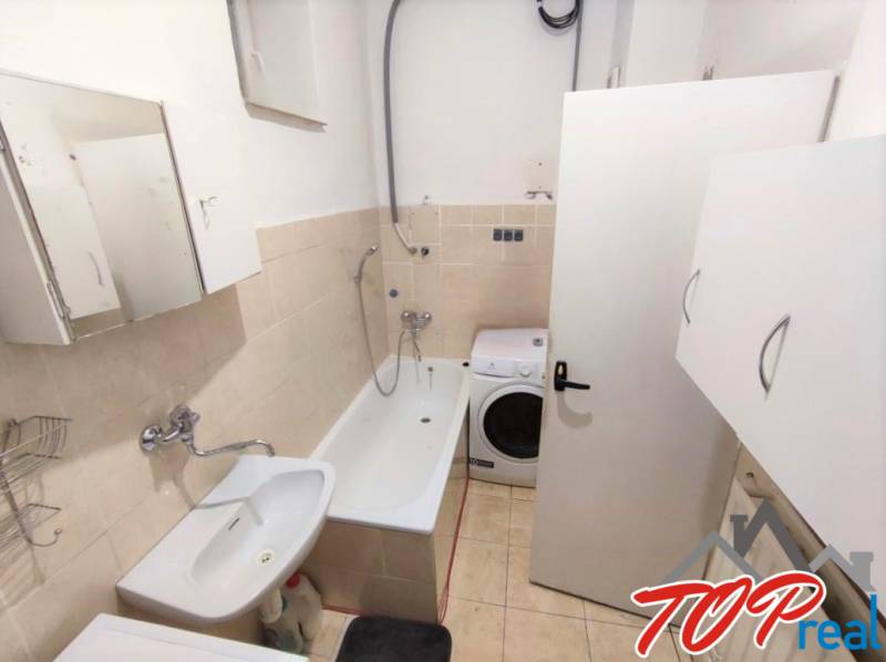 Bathroom with a bathtub, sink, and washing machine in a family house.