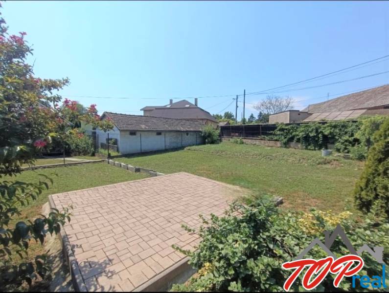 A garden at a family house in Veľká Ida with paving and flowers.