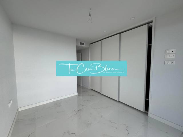 A room in a 3-room apartment with white walls and a marble-effect floor.