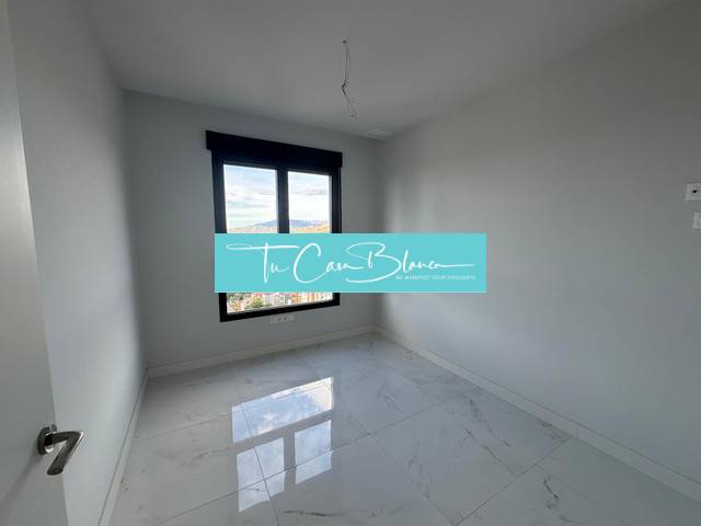 An empty room in a 3-room apartment with a marble floor and a large window.