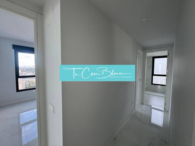 A hallway in a 3-room apartment with white walls and a glossy floor.