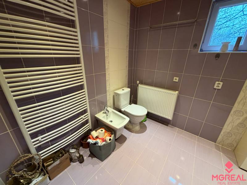 A bathroom in a family house with purple tiles and sanitary ware.