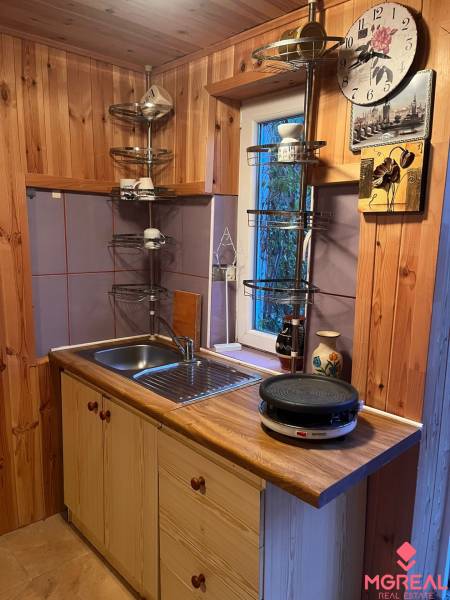 A kitchen in a family house with wooden paneling and a sink, time to cook.