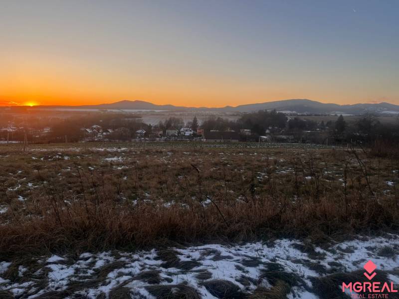Sunset over a snowy landscape and family houses in Tvrdomestice.