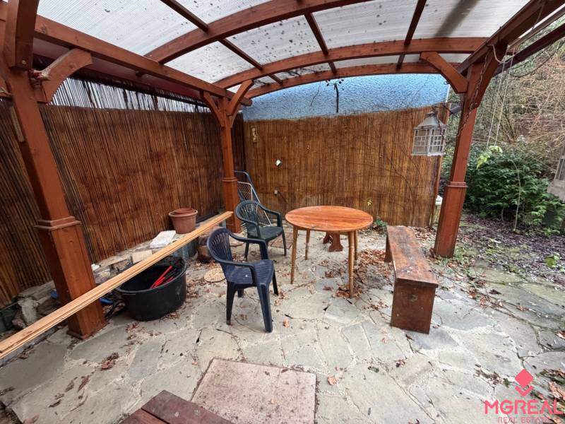 A shelter in the garden of a family house in Tvrdomestice, with wooden elements and furniture.