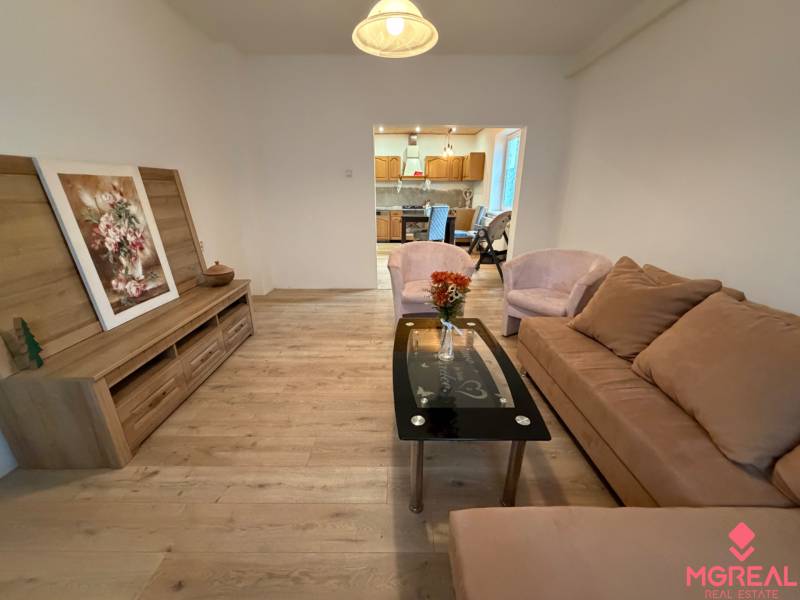 Living room in a family house with wood-patterned flooring and a comfortable sofa.