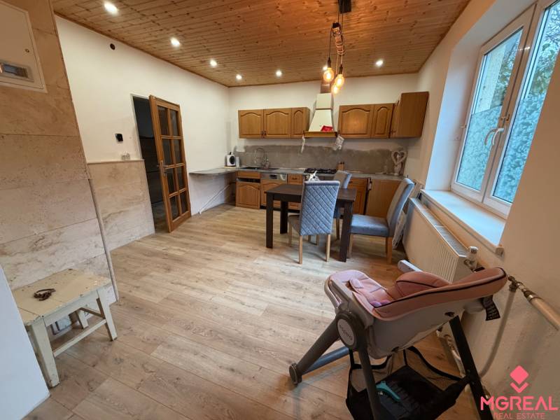 A kitchen in a family house with a wooden decor floor and a dining table.